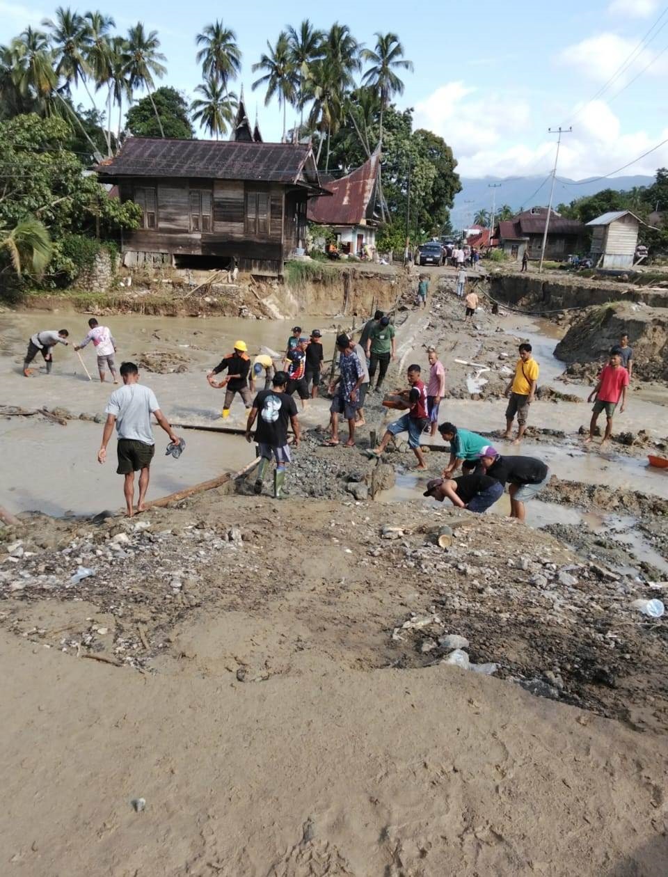 BENCANA SUSULAN: Warga Bancah, Maninjau, Kabupaten Agam, gotong royong membangun jembatan darurat usai dihantam banjir susulan, Minggu (7/12).