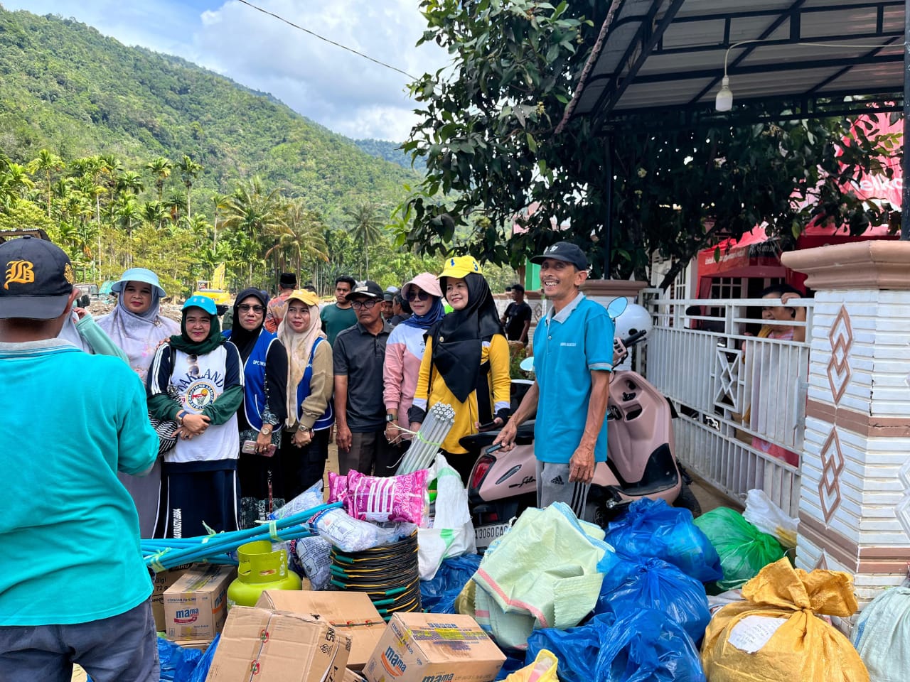 Ketua DWP Kabupaten Pessel, Ny Een Reva Yuliasman, (baju kuning) saat menyalurkan bantuan ke Kecamatan Bayang Utara. (Dok Imam)