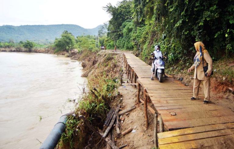 JEMBATAN DARURAT PASCABENCANA Warga melewati jembatan darurat di Nagari Sungai Buluh Timur, Kecamatan Batanganai, Kabupaten Padangpariaman, Senin (8/12).