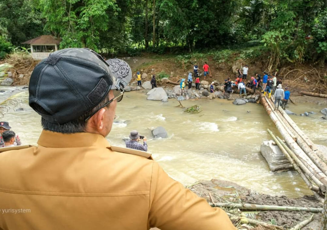 Bupati Tanahdatar Eka Putra meninjau jembatan darurat di Subarang Luak untuk memastikan bantuan logistik kembali lancar setelah banjir bandang.(Foto: Prokopim)