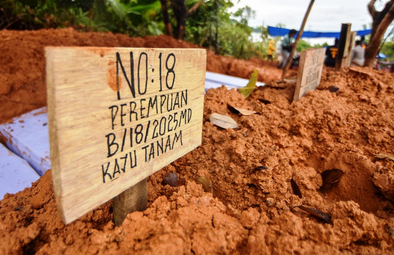 PEMAKAMAN MASSAL: Identitas sementara dituliskan pada 24 nisan korban banjir bandang saat pemakaman massal di Tempat Pemakaman Umum (TPU) Bungus, Kota Padang, Rabu (10/12).