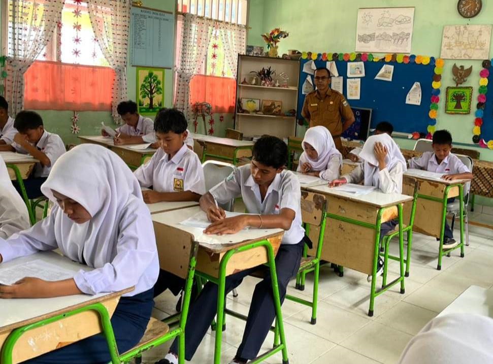 TETAP FOKUS: Sebanyak 113 pelajar SMPN 1 Batanganai harus menjalani ujian di SDN 11 Batanganai akibat putusnya jembatan di Sungai Buluah Timur, kemarin.