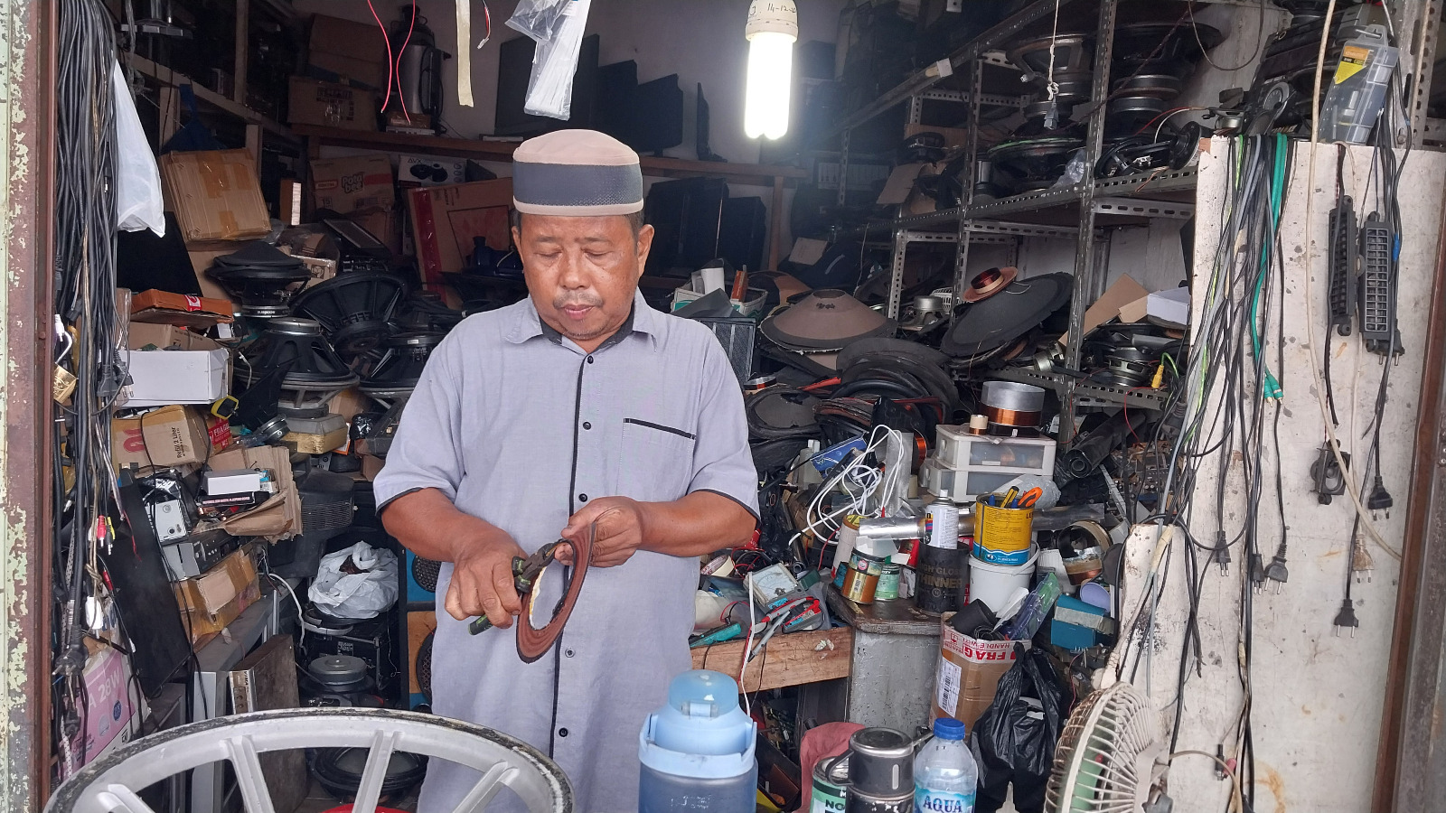 Zulhendri, pemilik Prima Elektronik di Pasar Raya Padang, sedang memperbaiki barang elektronik di tokonya.