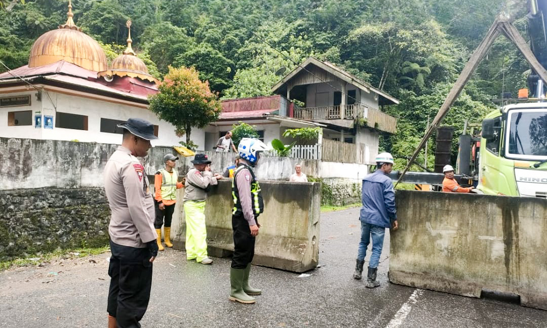Pemasangan portal beton oleh Polres Padangpanjang di jalur Lembah Anai untuk mendukung percepatan perbaikan jalan, Sabtu (13/12/2025).