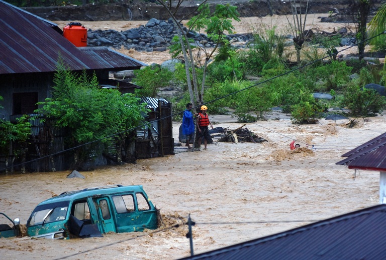 KEMBALI MELUAP: Tim SAR memandu warga menyeberangi air menggunakan tali di kawasan Batubusuk, Kecamatan Pauh, Kota Padang, Minggu (14/12).