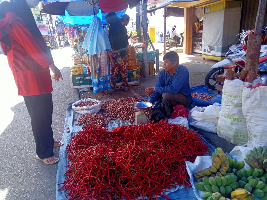 Pedagang cabai di Pasar Inpres Painan, Ahmad sedang melayani pembeli.