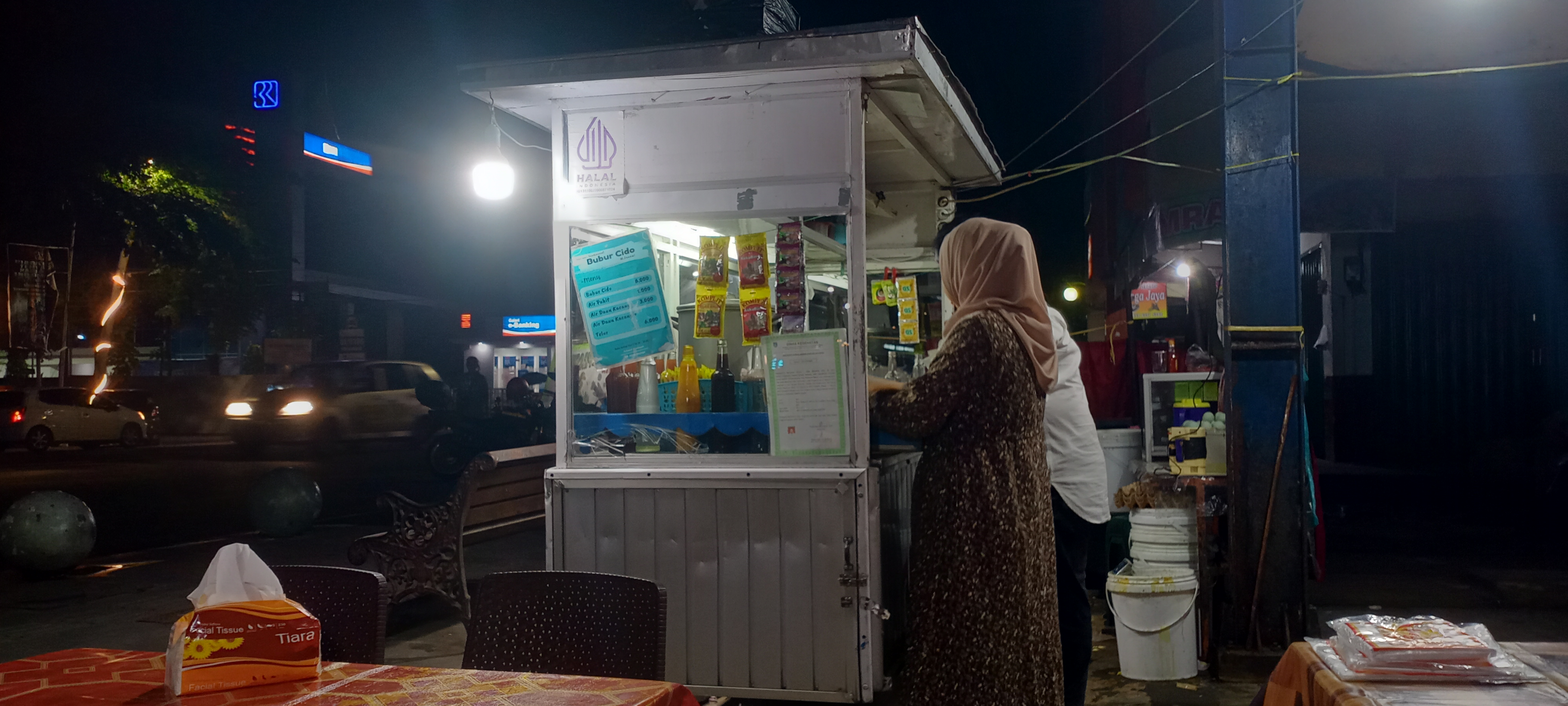 Lapak Bubur Cido yang dikelola Resti, di jalan Sudirman Kota Payakumbuh terlihat ia sedang melayani konsumen , Sabtu ( 13/12 ).