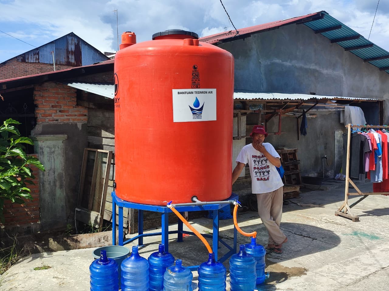 MENANTI PENUH: Salah seorang warga mengisi air dari tendon bantuan PDAM di Pratama 1 Blok H, Simpang Brimob, Lubukbuaya, Kecamatan Kototangah, Kota Padang, kemarin (16/12).