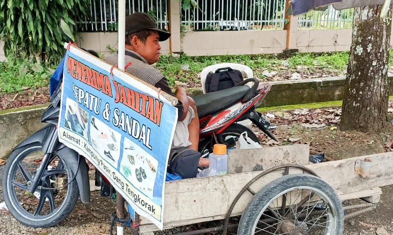 Pak Mawi, tukang sol sepatu keliling di Pasaman Barat, bertahan hidup dengan bengkel becak sederhana setelah usaha dagangnya tergerus belanja online. (Foto: Fadli Zikri/Padeks)