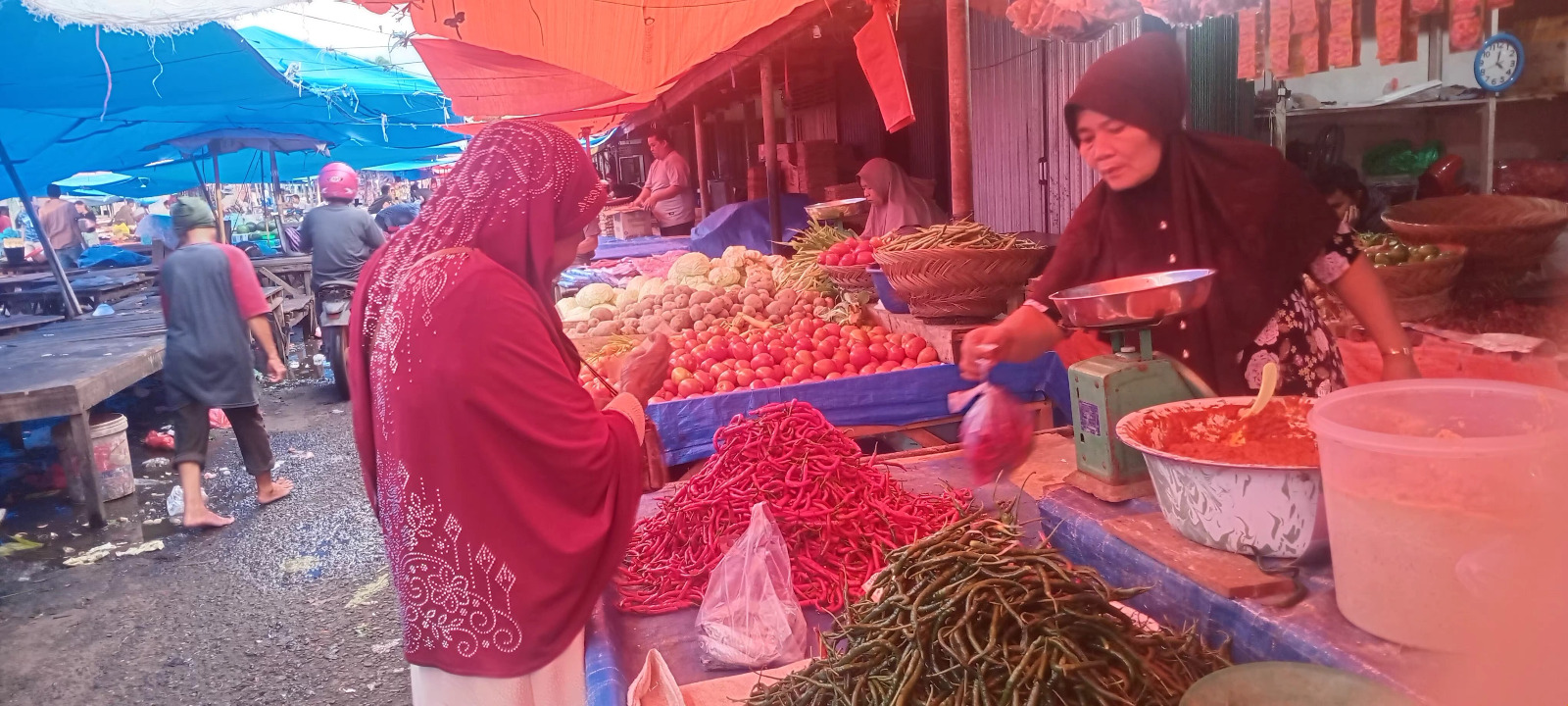 Salah seorang pedagang kebutuhan pokok di Pasar Lubukbasung sedang melayani pembeli, Rabu (17/12).
