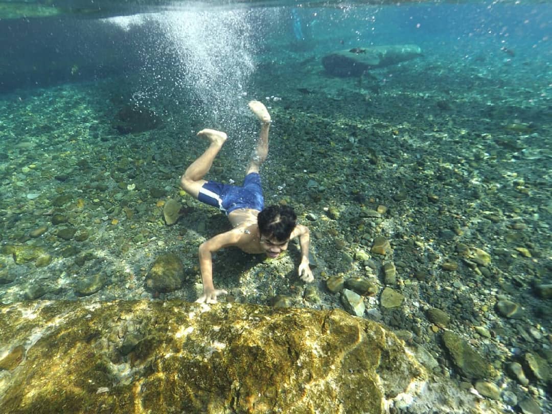 Salah seorang pengunjung menyelam menikmati segarnya air Pemandian Batang Tabik.