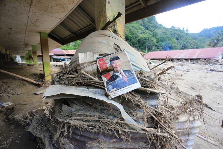 TERHEMPAS BANJIR: Poster Presiden Republik Indonesia Prabowo Subianto tertempel di kawasan Sekolah Dasar Negeri 3 Tripejaya yang rusak dan tertimbun material lumpur pasca bencana di Desa Uyeberirin.