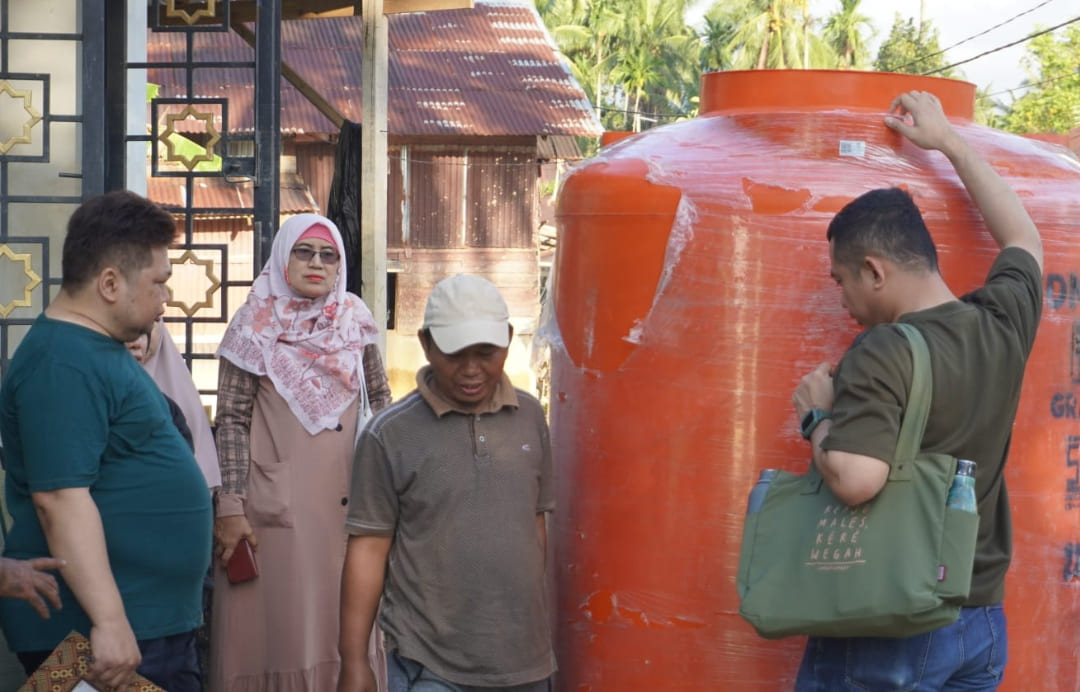 Tim PKM UNP serahkan bantuan tandon air dan logistik dapur umum kepada warga korban banjir bandang di Tabing Banda Gadang, Nanggalo, Padang, Minggu (21/12/2025).(Foto: Randi/Padek)