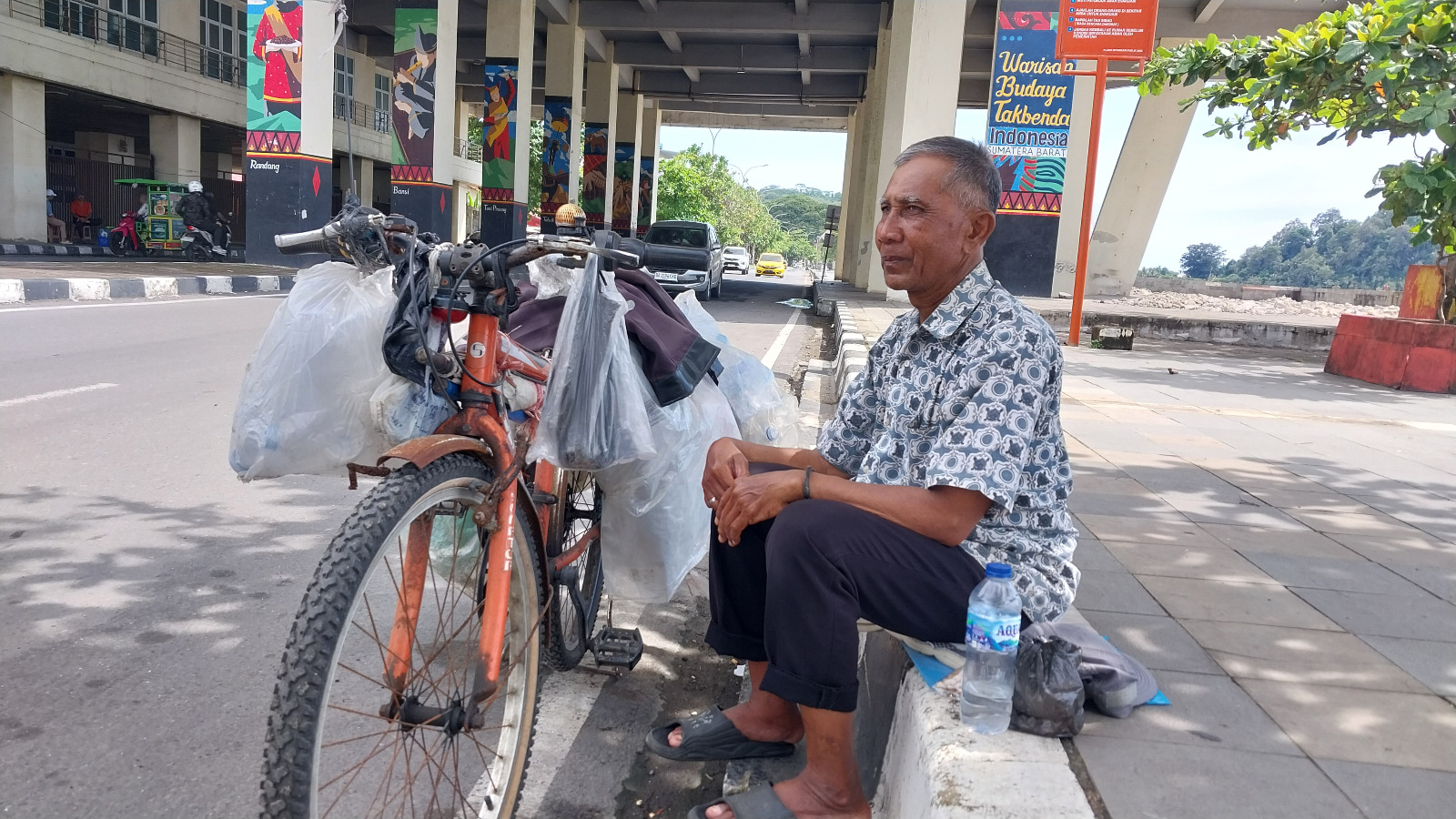 Indra Swandi, pemulung di kawasan Pantai Padang, sedang duduk beristirahat, Minggu (21/12).