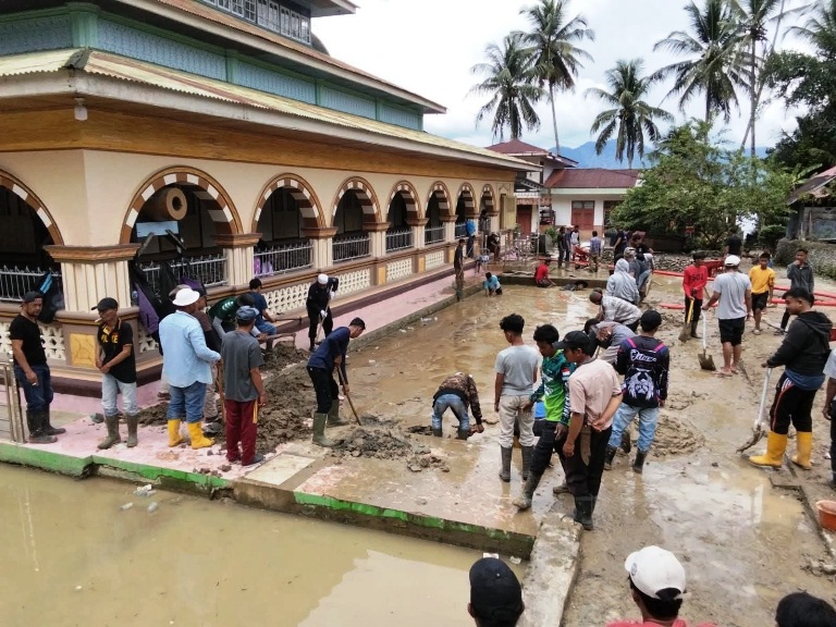 SOLIDARITAS: Warga Nagari Sungailandia, Kecamatan Ampekkoto, Kabupaten Agam beramai-ramai membersihkan lumpur sisa banjir di Jorong Bancah, Nagari Maninjau, Kecamatan Tanjungraya, Minggu (21/12).