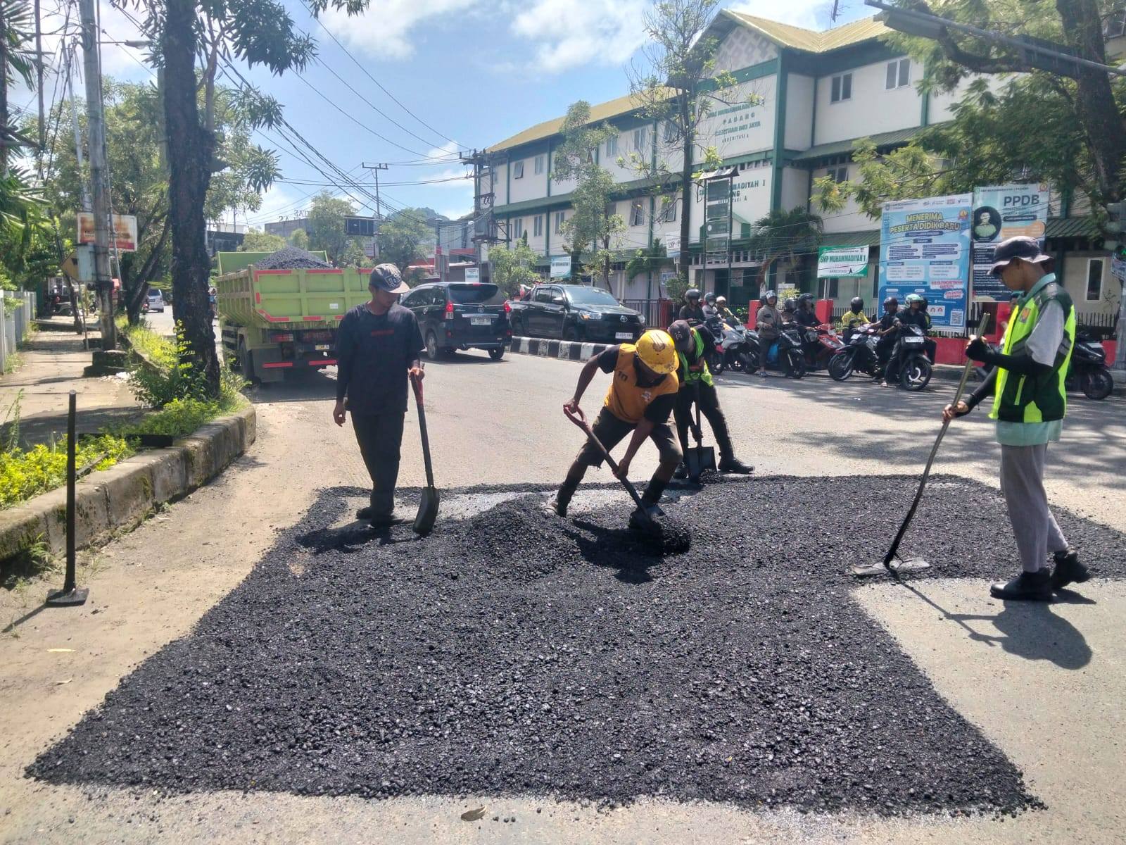 Petugas sedang melakukan penambalan aspal di salah satu jalan di Kota Padang.