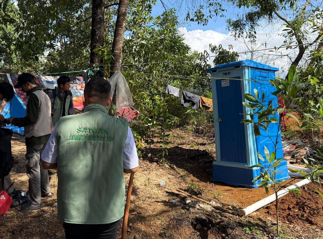 Tim PKM UNP saat penyaluran bantuan toilet portable di kawasan Batu Busuk, Kota Padang, Jumat (26/12/2025).(Foto: Randi/Padek)