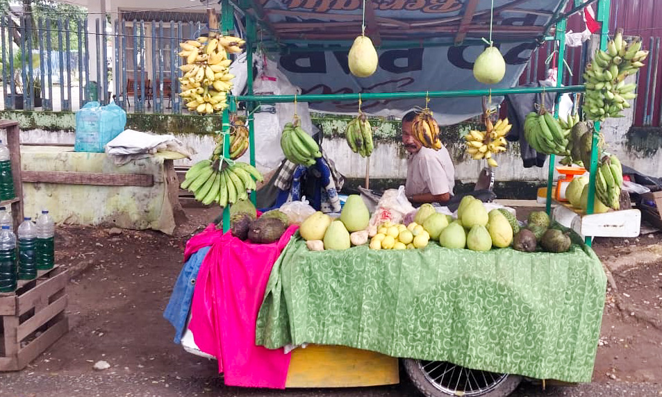 Zahril ketika menunggu pembeli di lapak buah miliknya, Jl. Batang Kapur, Alai Parak Kopi, Padang Utara, Kota Padang, Sabtu (27/12/2025). (Foto: Mengki Kurniawan/Padeks)