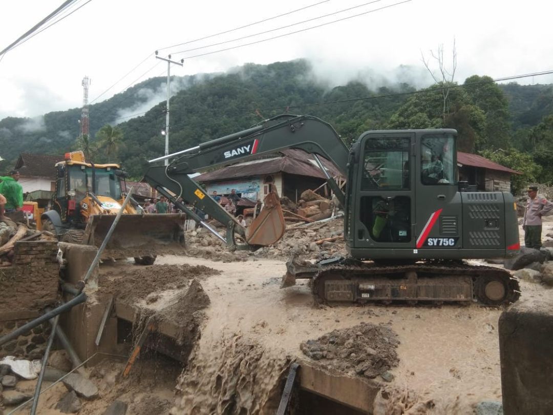 Akses Lubukbasung-Bukittinggi kembali tertutup material galodo di Pasa Maninjau, Tanjungraya, Minggu (28/12) sore. Alat berat di-standby-kan di lokasi untuk pembersihan.