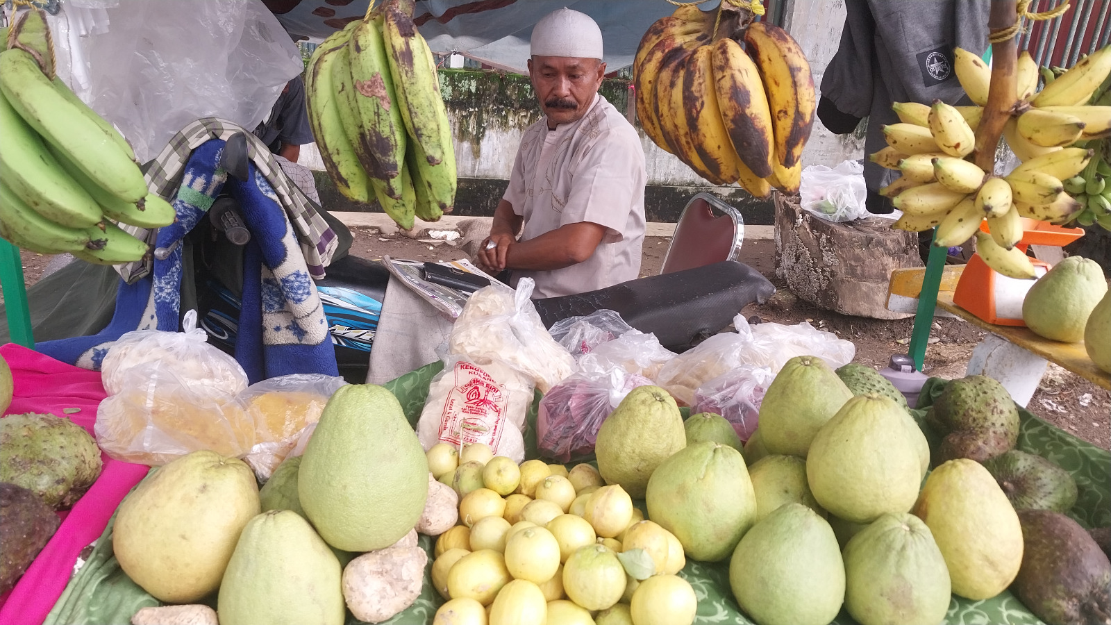 Zahri, penjual buah keliling, saat menunggu pembeli.