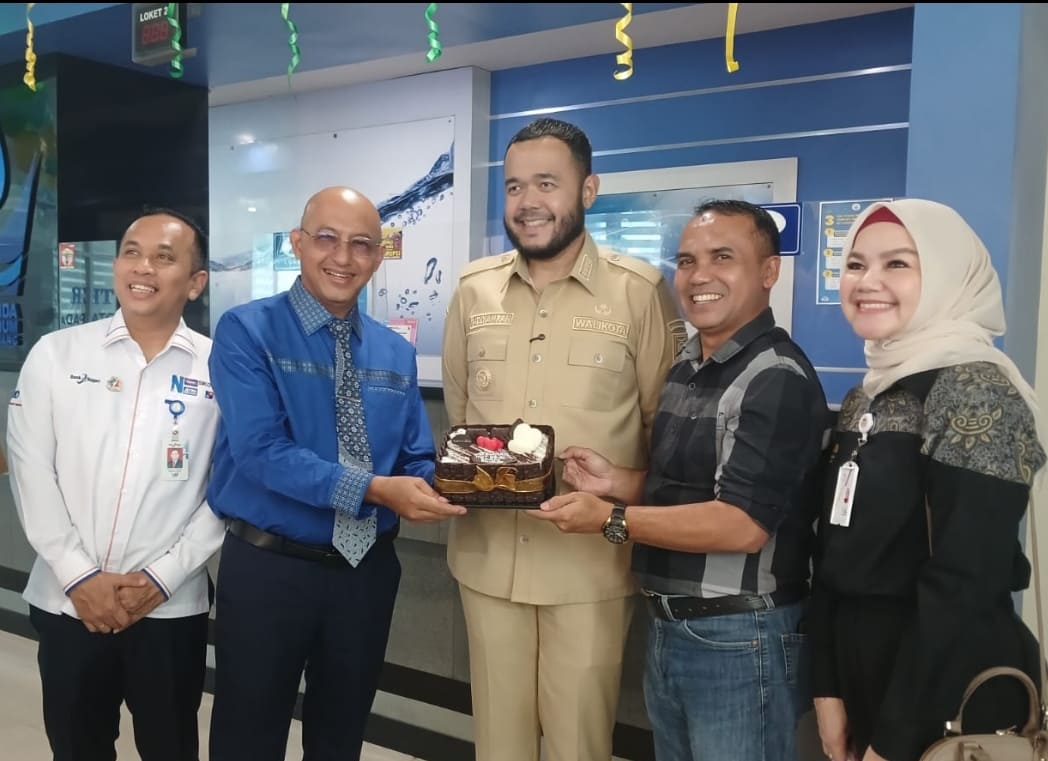 Dirut Padang Ekspres Mhd Nazir Fahmi menyerahkan kue ulang tahun kepada Dirut Perumda AM Kota Padang Hendra Pebrizal, disaksikan Wali Kota Padang Fadly Amran pada HUT ke-51.(Foto: Suryani)