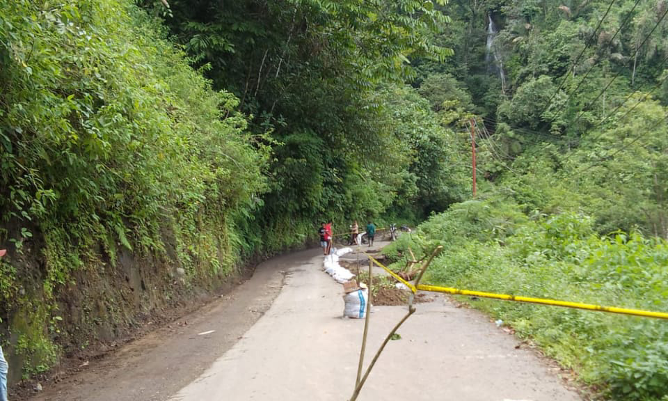 Kondisi badan jalan di Kabupaten Pasaman yang tersisa separuh pascabanjir dan longsor, memaksa pengemudi ekstra berhati-hati karena berisiko terjun ke sungai, Selasa (30/12/2025).