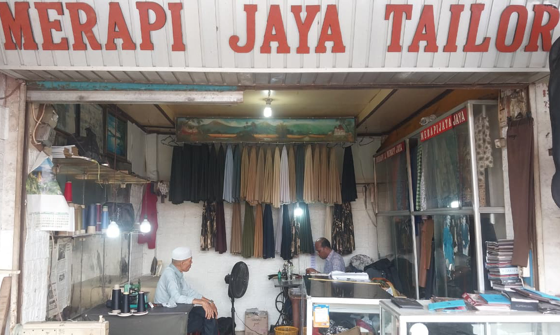 Usaha jahit Merapi Jaya di Pasar Raya Padang bertahan meski pesanan Nataru menurun akibat tekanan ekonomi dan persaingan e-commerce.