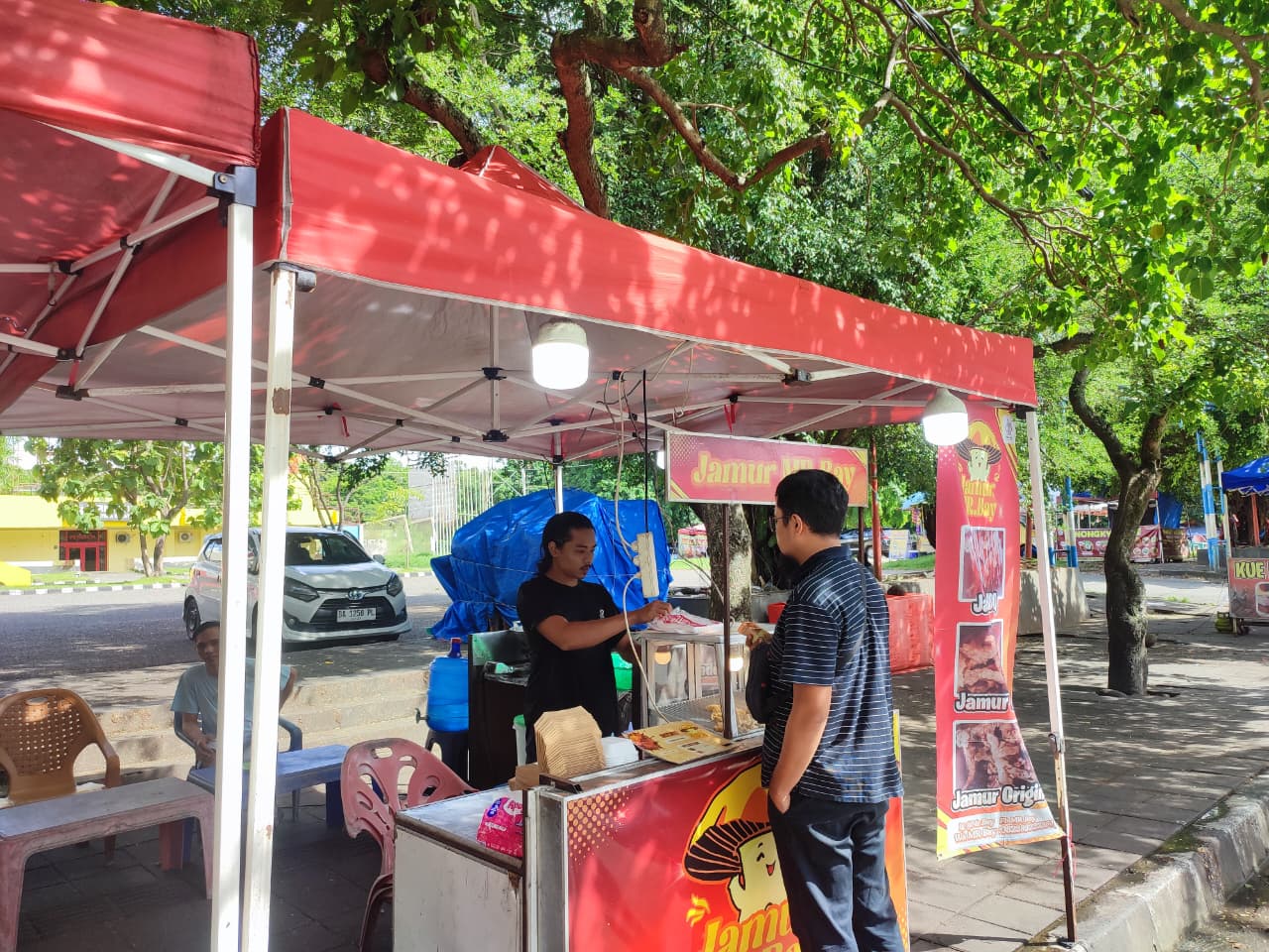 Salah seorang pedagang makanan di kawasan GOR H. Agus Salim Padang sedang melayani pembeli, kemarin.