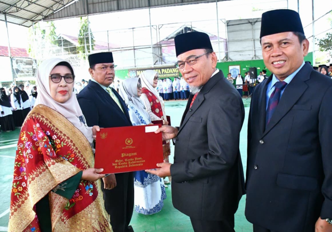 Wawako Maigus Nasir serahkan Satya Lencana Karya Satya kepada ASN berprestasi pada peringatan HAB ke-80 di MAN 2 Padang, Sabtu (3/1/2026).(Foto: Prokopim)