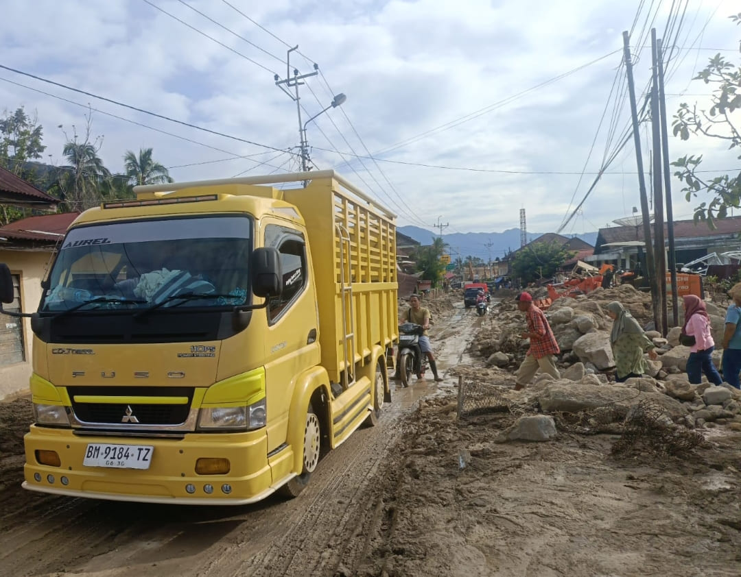 Alat berat membersihkan material longsor di jalan Lubukbasung&ndash;Bukittinggi, Maninjau, Agam, sehingga arus lalu lintas kembali lancar.(Foto: Putra/Padek)