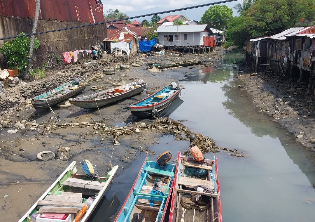 Kapal nelayan kandas saat surut ekstrem akibat fenomena Supermoon di Batang Arau, Padang, Minggu (4/1/2026). Aktivitas nelayan tetap berjalan sambil menunggu air pasang.(Foto: Mengki Kurniawan)