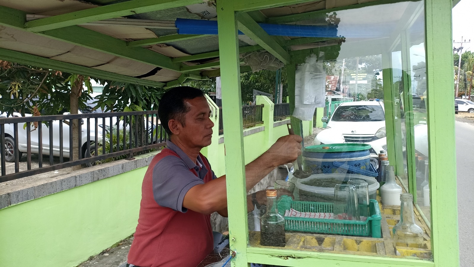 LAYANI PEMBELI : Seorang pedagang aia aka melayani pembeli di lapaknya di Jalan M. Natsir, Kecamatan Pasaman, Kabupaten Pasaman Barat, Senin (5/1).