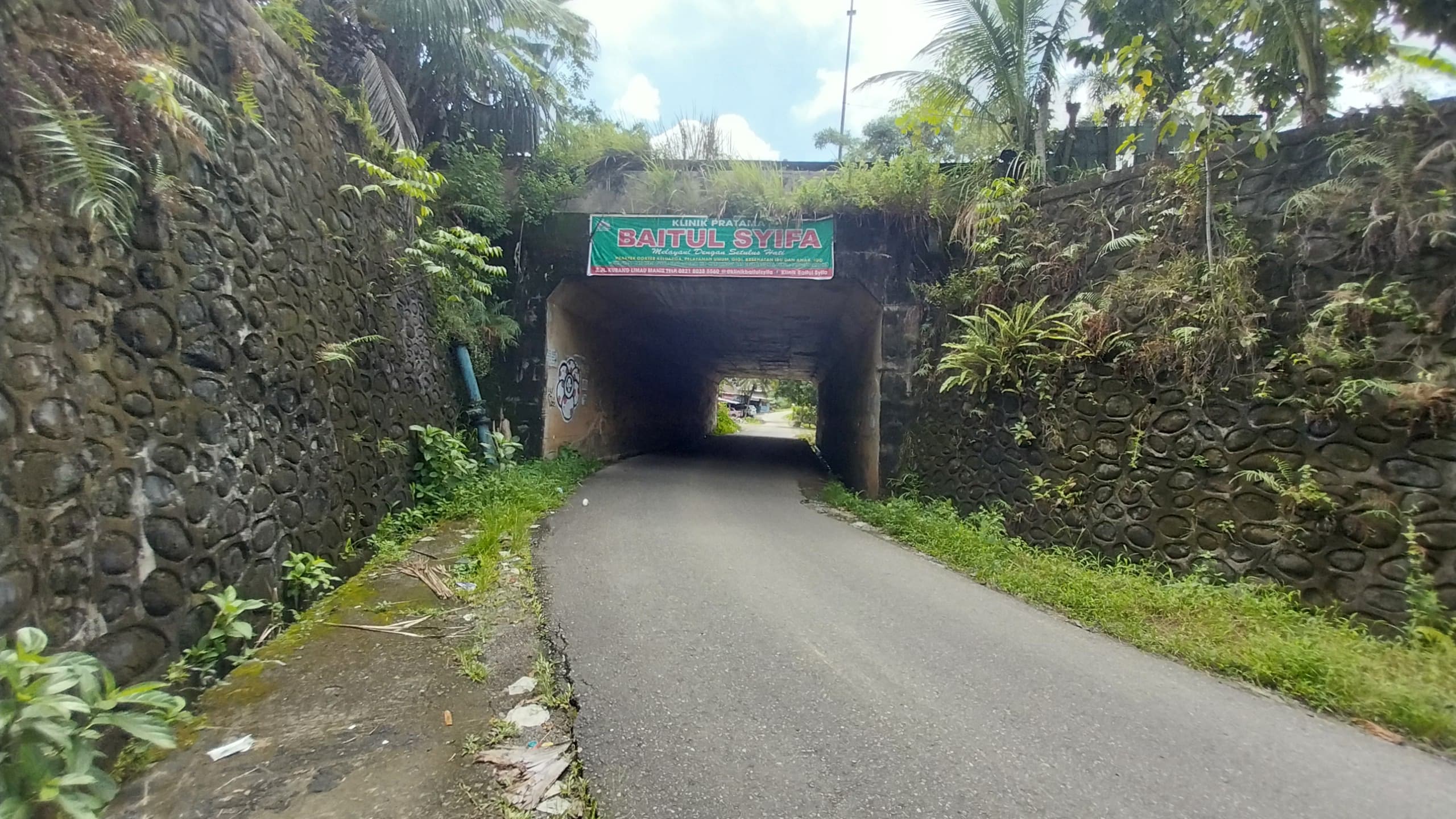 Warga mengeluhkan terowongan di bawah gerbang Unand yang gelap total tanpa lampu, dinilai rawan kecelakaan dan mendesak pemasangan penerangan jalan.(Foto: Mengki Kurniawan/Padeks)