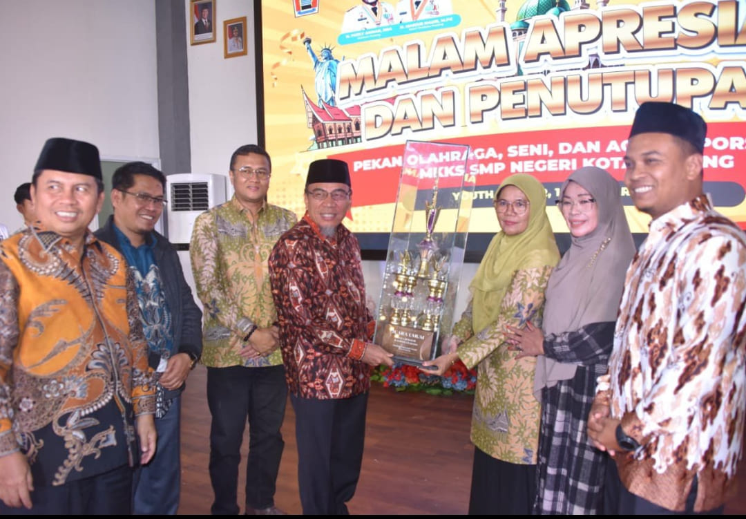 Wakil Wali Kota Padang, Maigus Nasir menyerahkan trofi Juara Umum PORSEMA II kepada perwakilan SMP Negeri 34 Padang di Gedung Bagindo Aziz Chan Youth Center, Rabu (14/1/2026).(Foto: Prokopim
