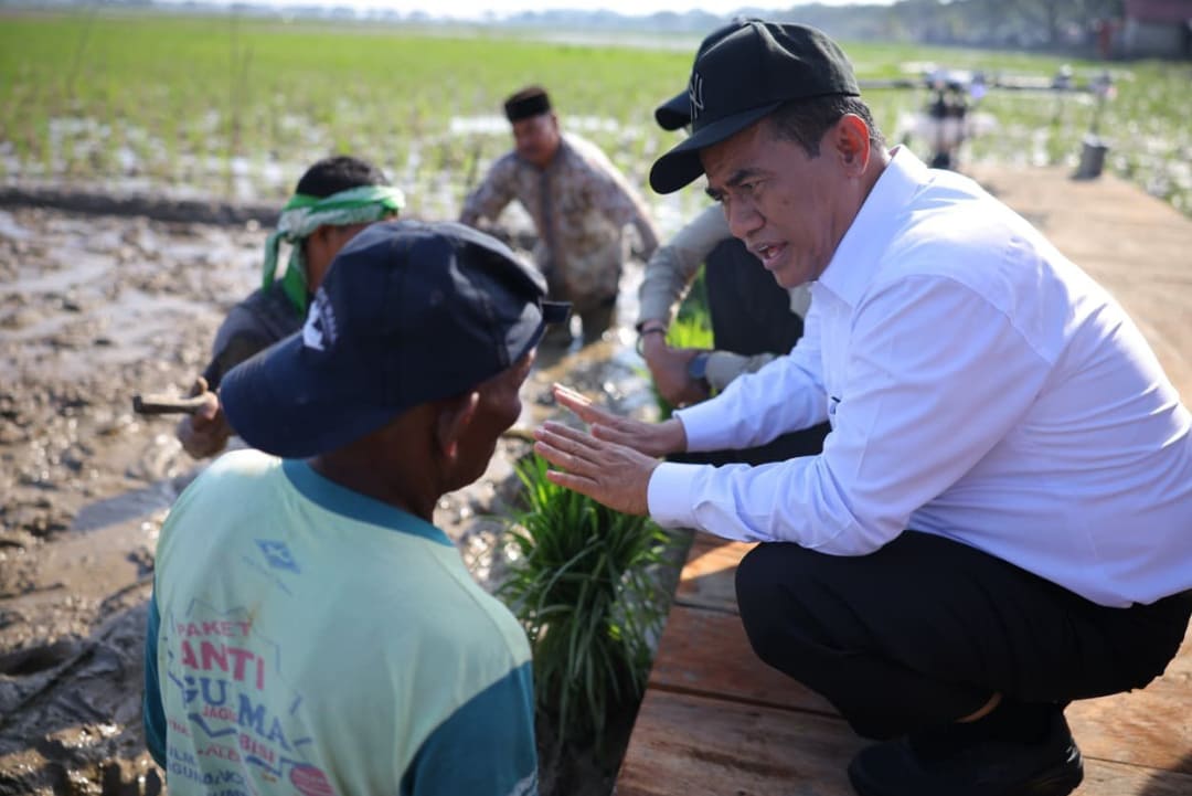 Menteri Pertanian Andi Amran Sulaiman berbincang dengan petani di Aceh saat memulai rehabilitasi lahan sawah terdampak bencana.(Foto: Humas Kementan)