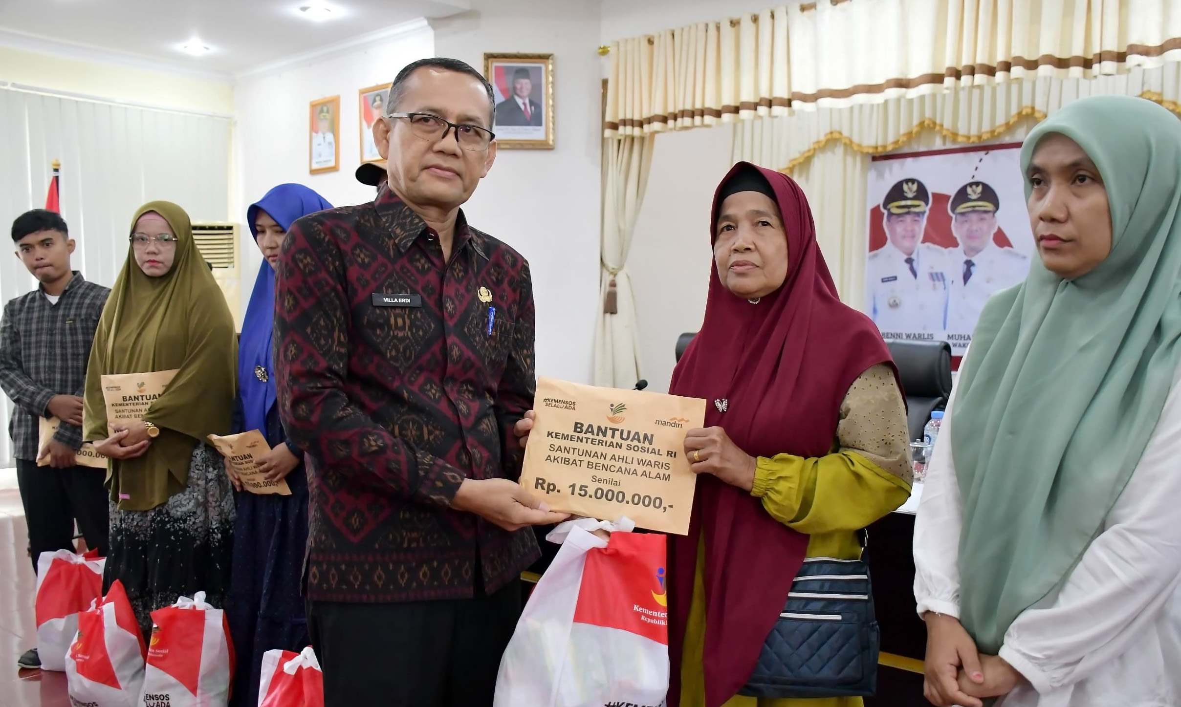 Kepala Dinas Sosial Agam, Villa Erdi, menyalurkan santunan uang duka dari Kementerian Sosial kepada ahli waris korban bencana di Kantor Bupati Agam, Kamis (15/1/2026). (Putra Susanto/Padeks)