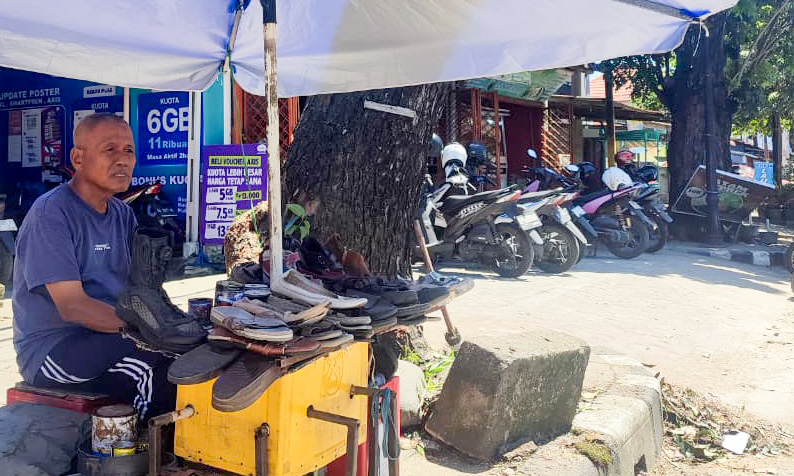 Bustami, tukang reparasi sepatu di Jalan Juanda Padang, bertahan sejak 2007. Ia bekerja demi keluarga dan berhasil menyekolahkan anak hingga S2. (Foto: Riyadhatul/Padeks)