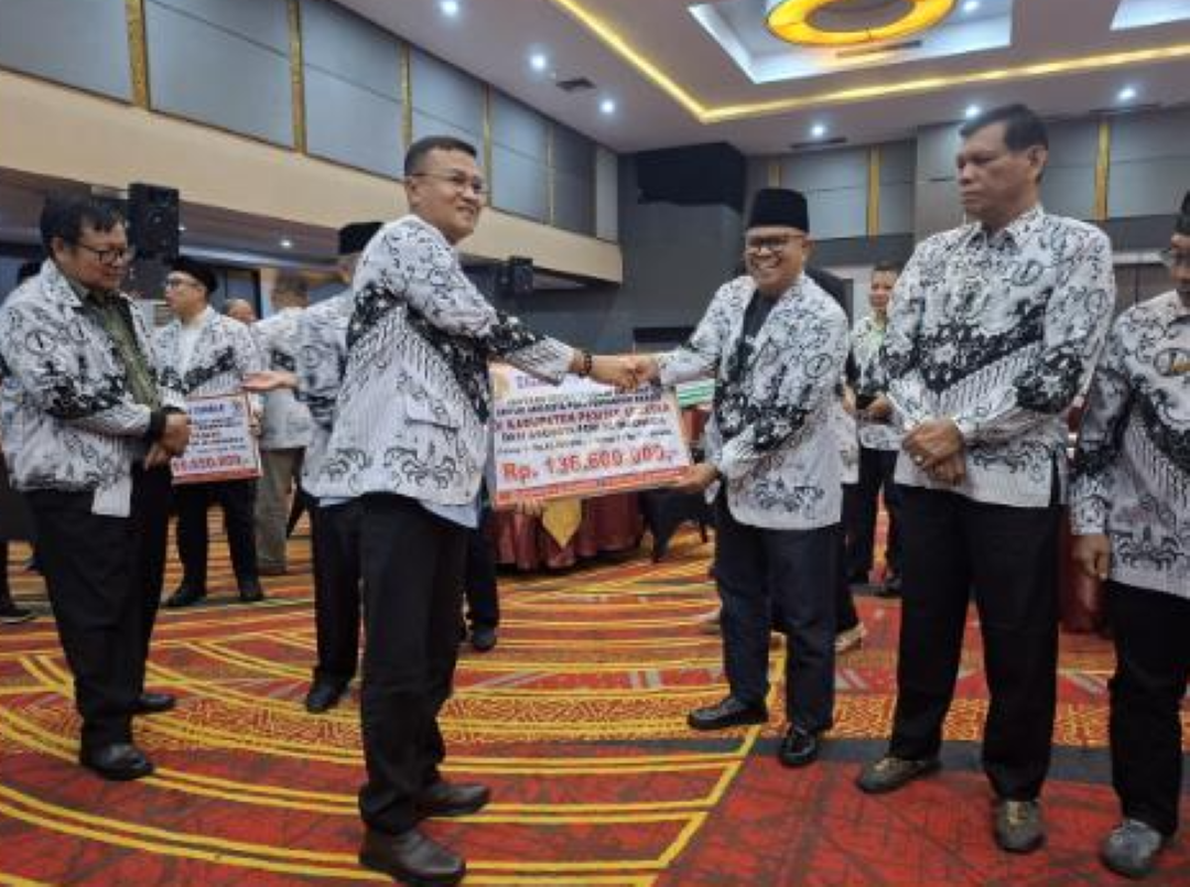 Ketua PGRI Pessel Darmawi (kanan) saat menerima bantuan bencana di Hotel Truntum Padang.