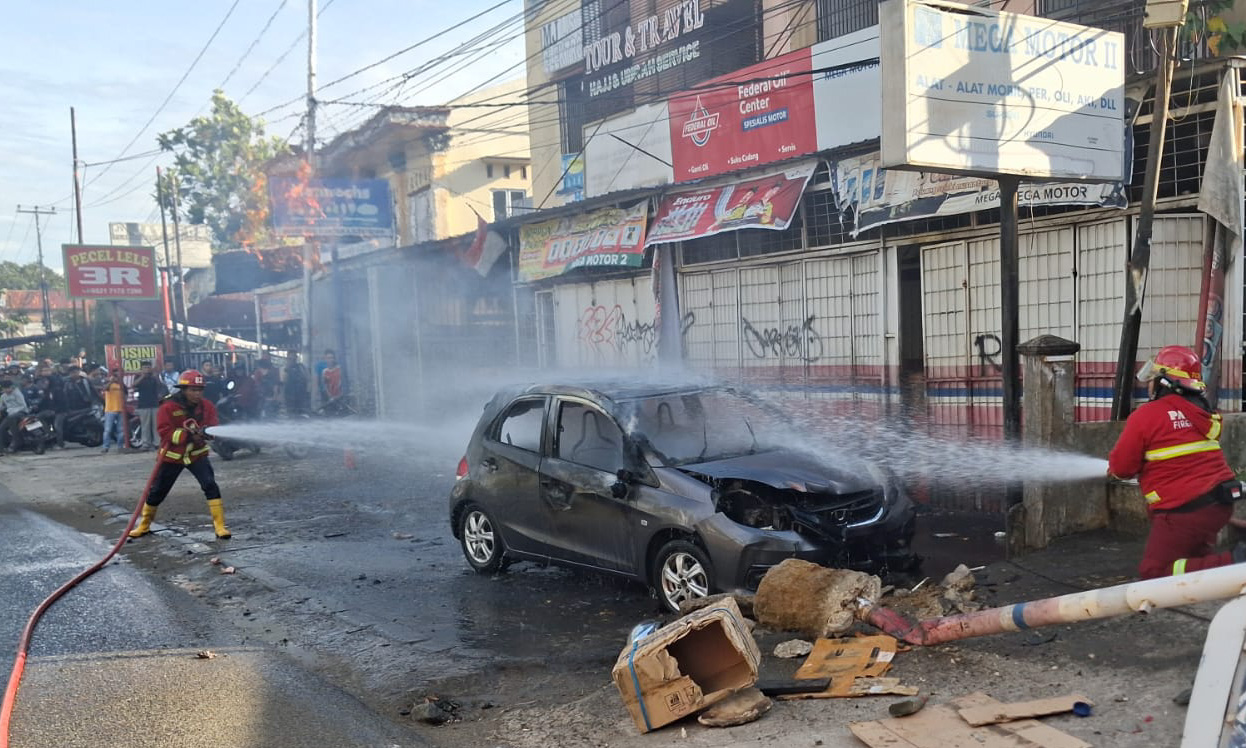 Mobil terbakar di Jalan Adinegoro Padang, Selasa sore. Damkar temukan jeriken minyak di dalam kendaraan, kerugian ditaksir Rp100 juta.