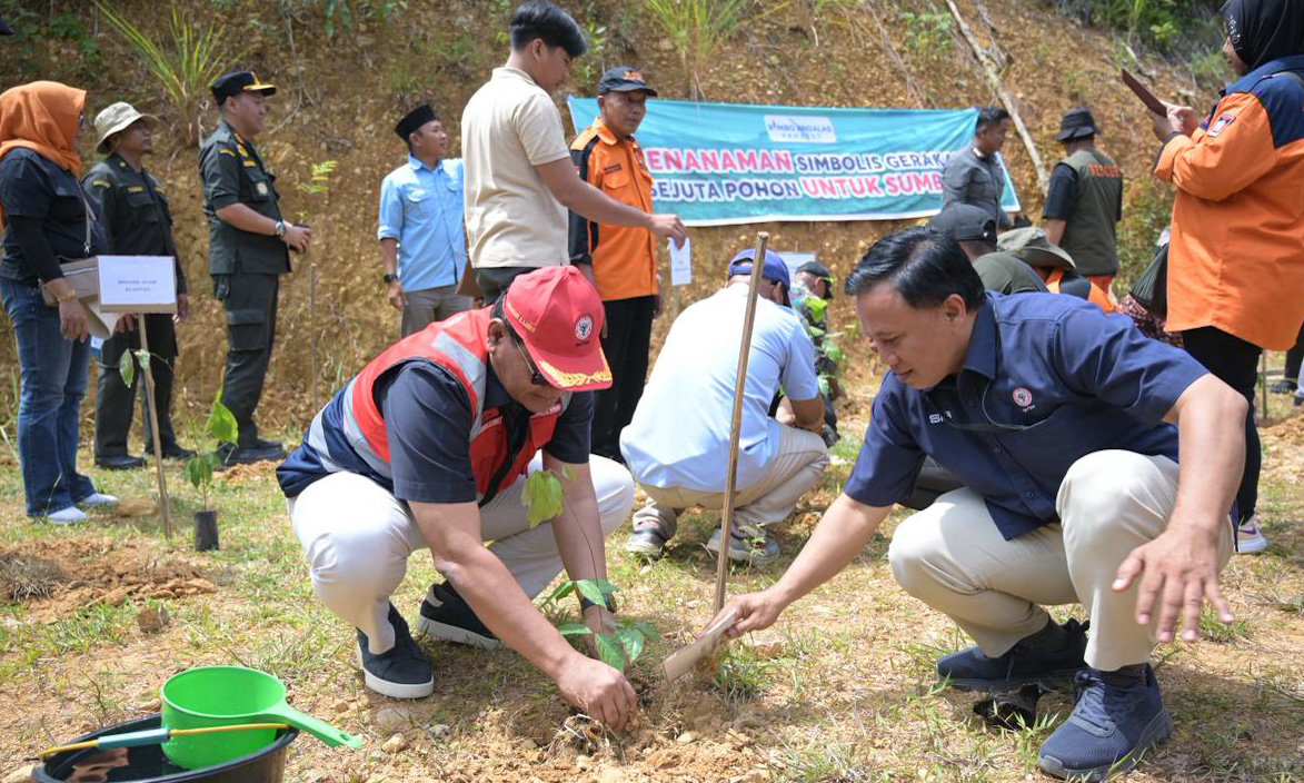 Direktur Keuangan PT Semen Padang Iskandar Z Lubis didampingi staf Humas PTSP, Oktaveri, menanam bibit kaliandra di kawasan Pemandian Jembatan Sitapuang, Kota Padang, Kamis (22/1/2026).