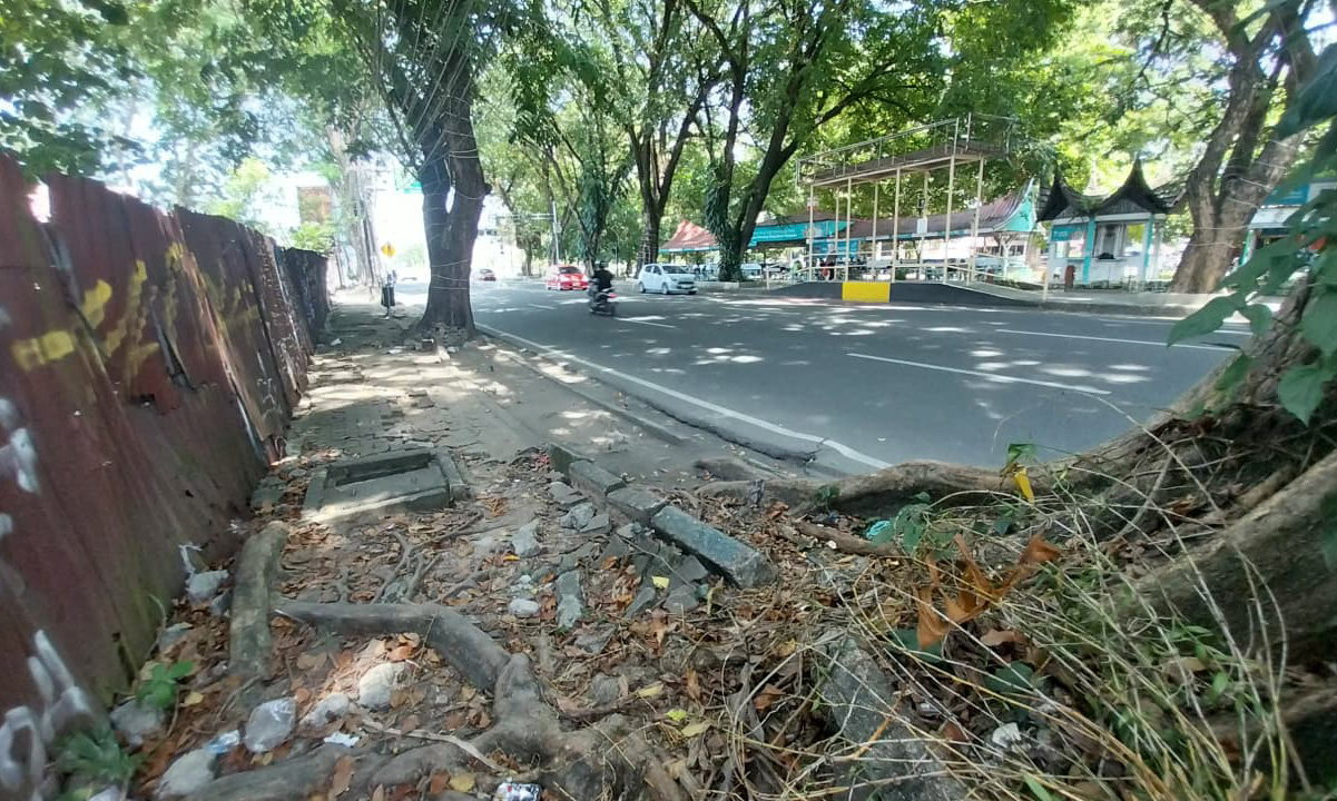Trotoar Jalan Rasuna Said, Kota Padang, rusak parah akibat akar pohon. Pejalan kaki terpaksa turun ke jalan dan dinilai membahayakan keselamatan. (Foto: Mengki Kurniawan/Padeks)