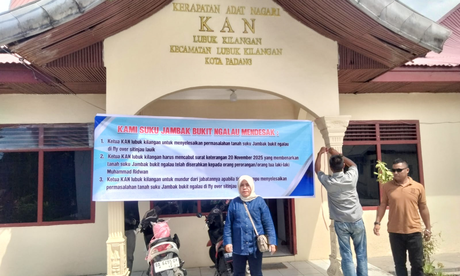 Maimunah memasang spanduk di Kantor KAN Lubuk Kilangan, Kota Padang, Kamis (29/1/2026), menyampaikan tiga tuntutan.