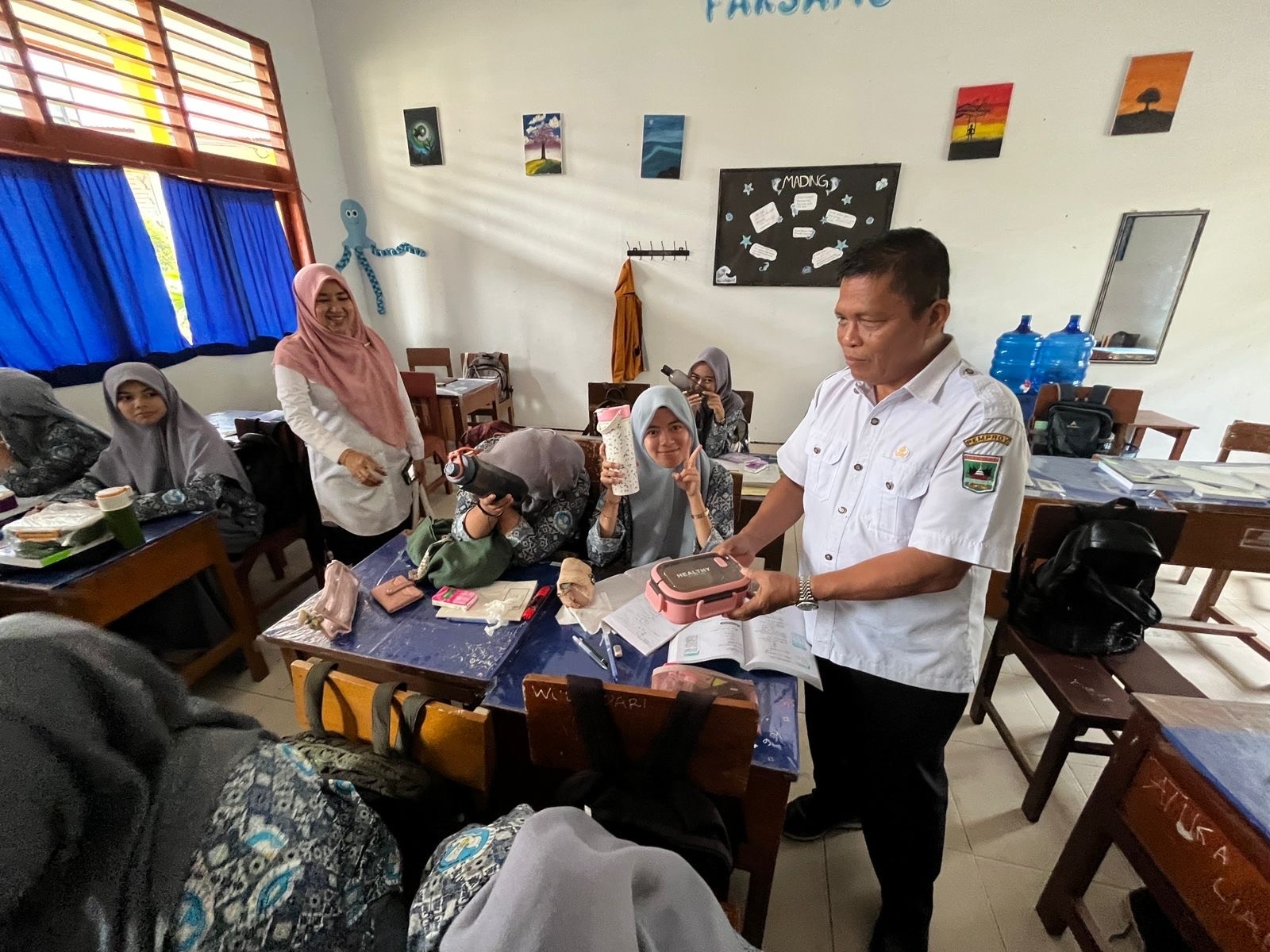 Kepala SMAN 1 Lareh Sago Halaban Masdal Fitri melihat siswa makan siang, kemarin. Ia berharap program MBG sampai di sekolahnya.