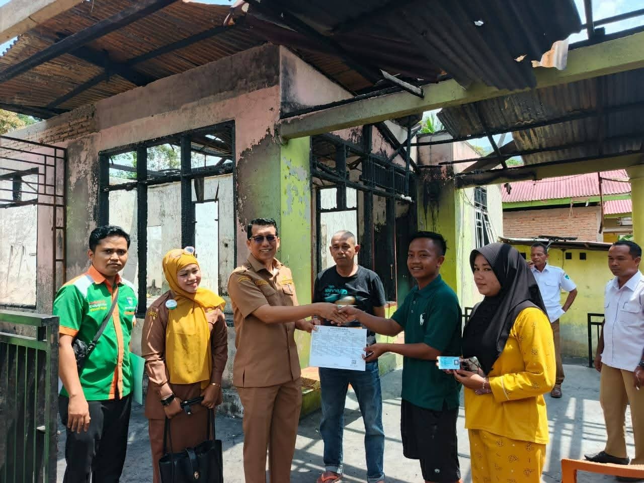 Kepala Dinas Dukcapil Pessel, Beriskhan saat menyerahkan dokumen kependudukan kepada salah satu korban kebakaran di Nagari Barung Barung Belantai, beberapa waktu lalu.
