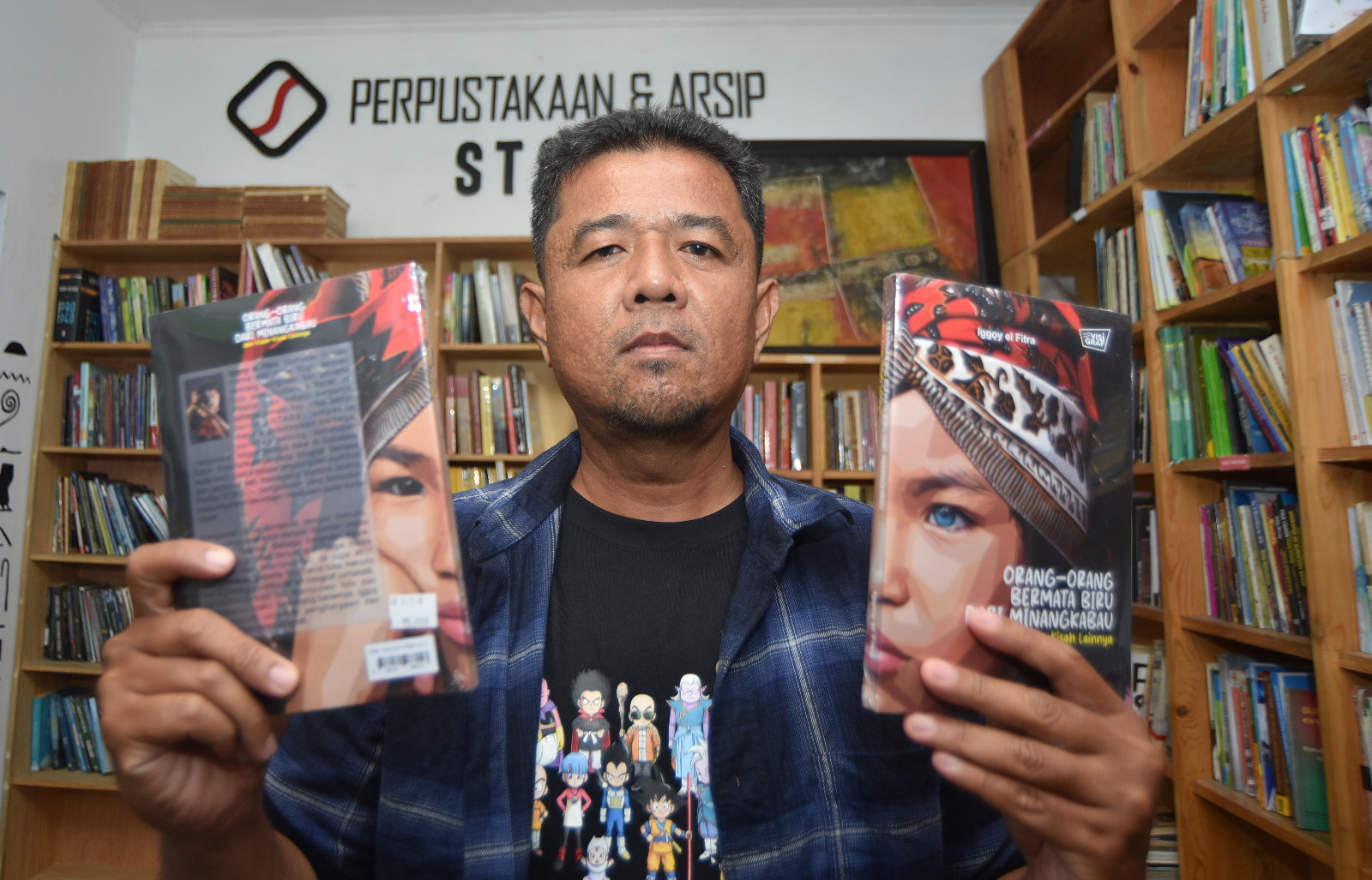 Pewarta foto ANTARA Iggoy el Fitra menunjukan bukunya saat peluncuran dan diskusi buku di Pustaka Steva Padang, Sumatera Barat, Sabtu (31/1/2026).