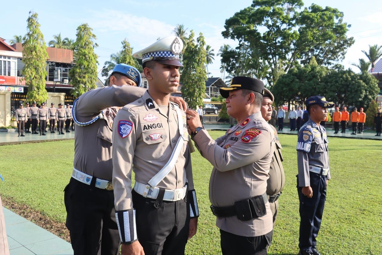 Kabag Ops Polres Pasbar Kompol Muzhendra menyematkan pita pencanangan Operasi Keselamatan Singgalang 2026 pada personel saat apel gelar pasukan di Mapolres Pasbar, Senin (2/2).