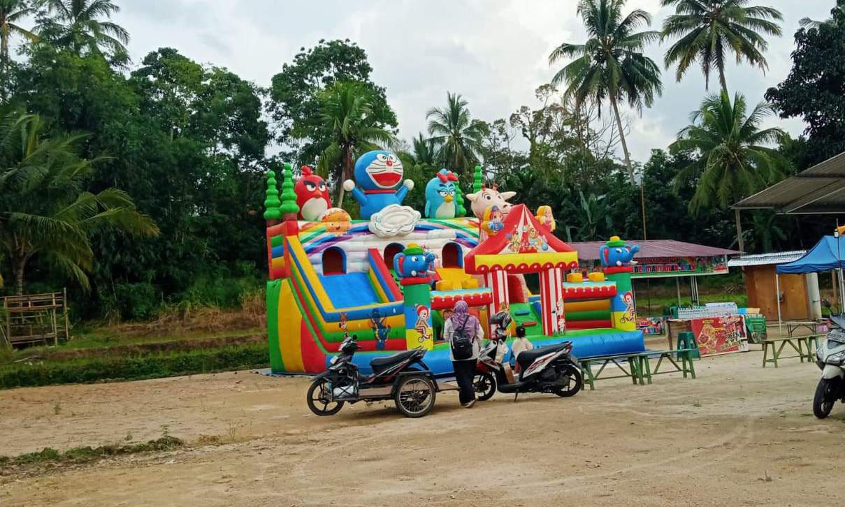 Anak-anak bermain wahana istana balon di kawasan Normalisasi Batang Agam, Jalan Kelok, Kelurahan Tanjung Pauh, Jumat (6/2/2026), yang kini dimanfaatkan warga sebagai ruang publik sore hari.