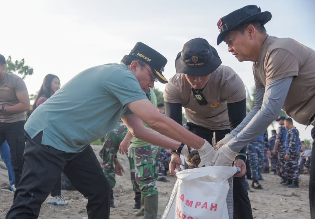 Wakil Wali Kota Padang Maigus Nasir memasukkan sampah ke karung saat aksi bersih Pantai Padang bersama TNI-Polri dan Pemko.(Foto: Prokopim)