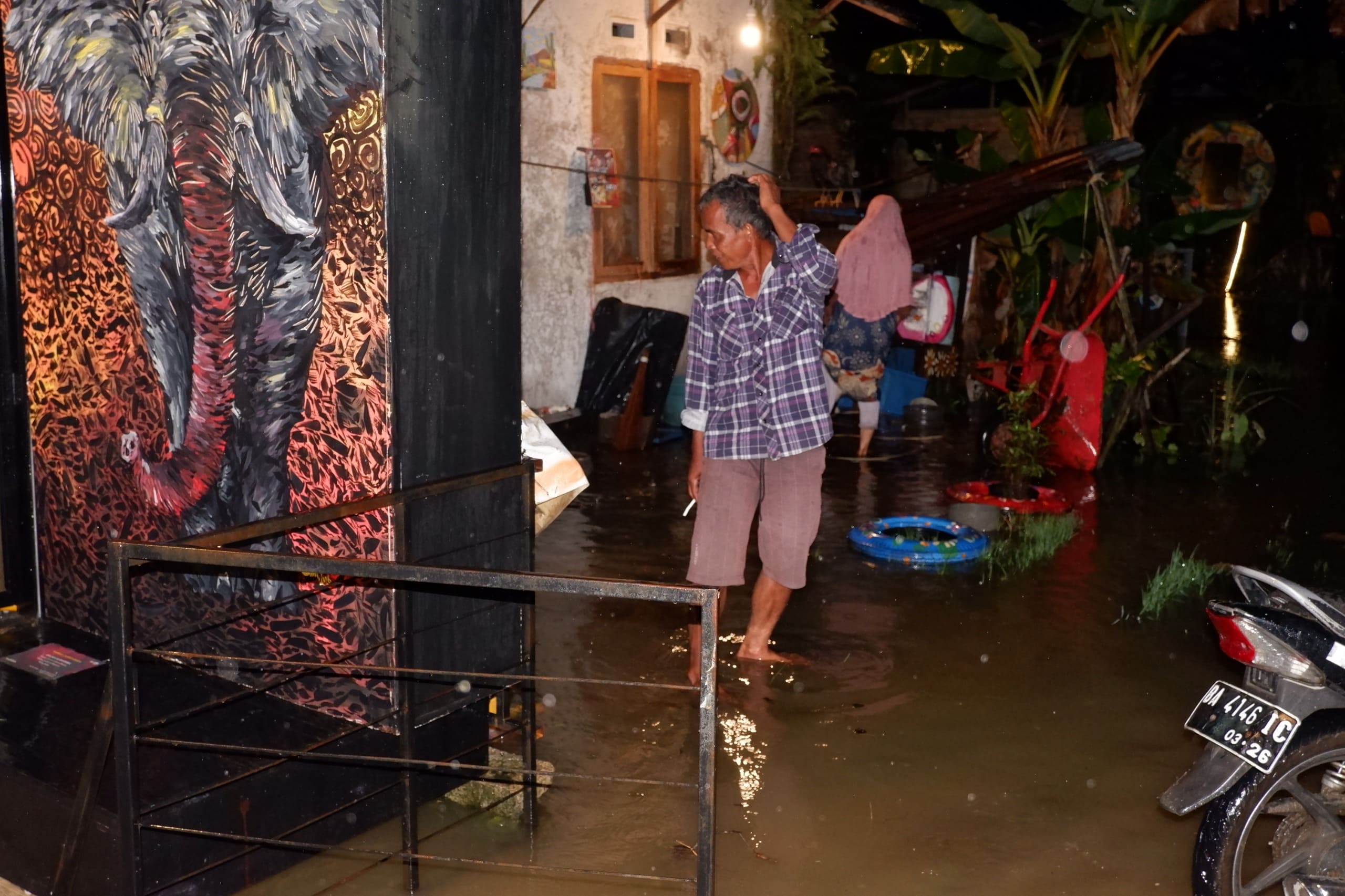 Lukisan dan instalasi seni menempel di dinding dan teras rumah warga Korong Kasai, menyatu dengan genangan banjir. (Foto: Dok. Komunitas Nan Tumpah)