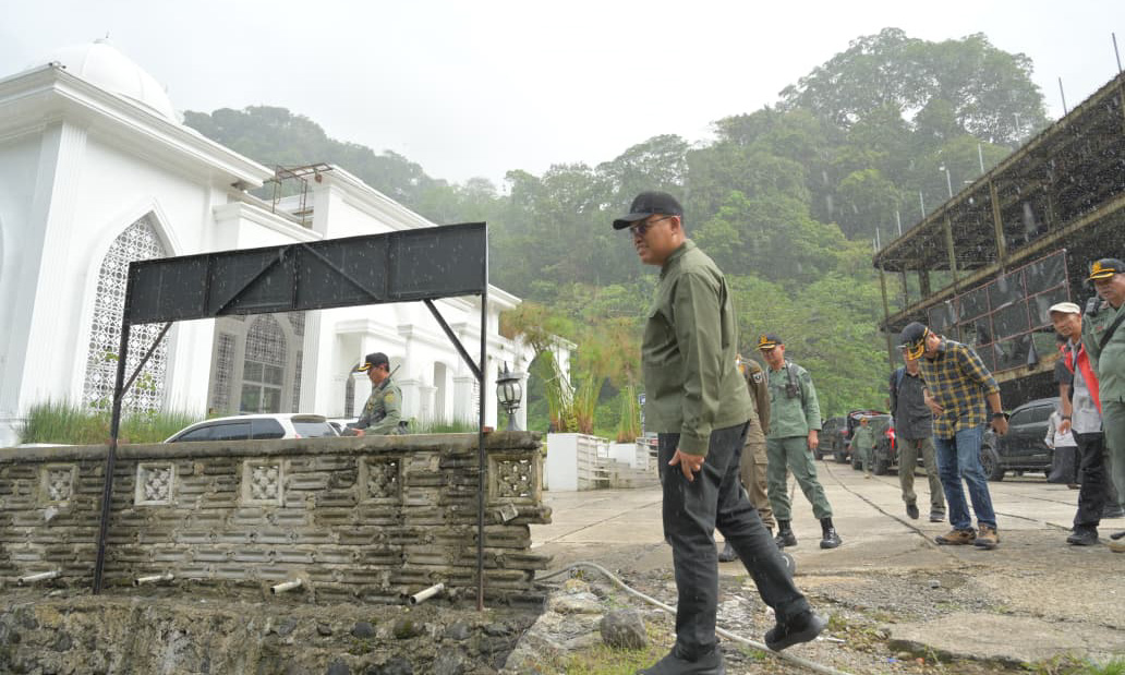 Sekdaprov Sumbar Arry Yuswandi berada di antara dua bangunan yang akan ditertibkan di bantaran sungai kawasan Lembah Anai, Senin (16/2/2026).